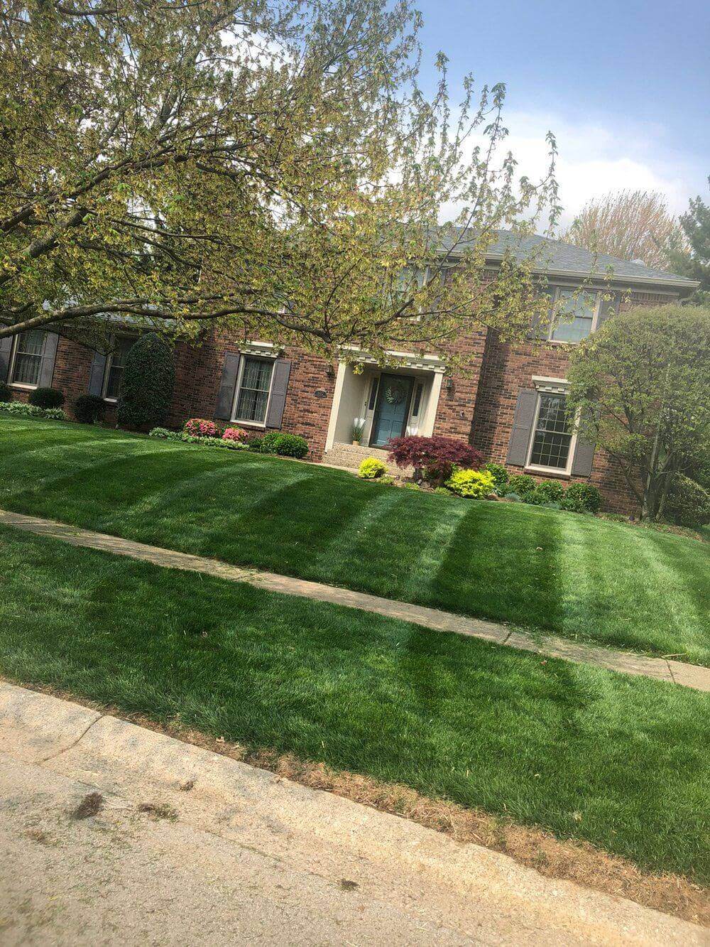 A freshly manicured lawn at a two story brick house